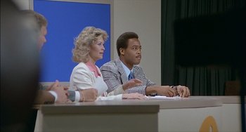 Movie still from “The Howling” (1981), directed by Joe Dante – A man and a woman sitting in front of a microphone; Medium shot, Over the shoulder angle