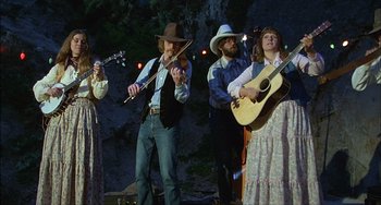 Movie still from “The Howling” (1981), directed by Joe Dante – A group of people playing music on a stage; Wide shot, Low angle