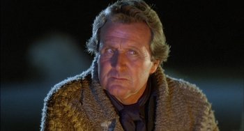 Movie still from “The Howling” (1981), directed by Joe Dante – An older man wearing a fur coat and a neck tie; Close Up shot, Low angle