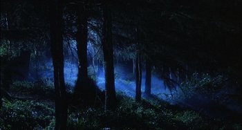 Movie still from “The Howling” (1981), directed by Joe Dante – A dark forest is lit up with blue lights; Extreme Wide shot, High angle