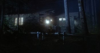 Movie still from “The Howling” (1981), directed by Joe Dante – A house that has a light shining on it; Extreme Wide shot, Low angle