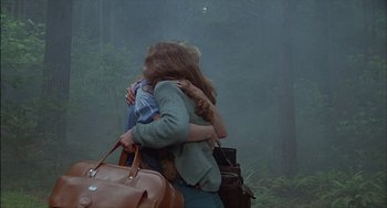 Movie still from “The Howling” (1981), directed by Joe Dante – Two people hugging each other in the woods; Wide shot, Over the shoulder angle