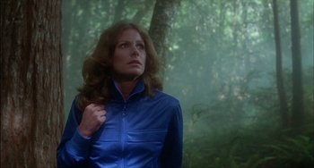 Movie still from “The Howling” (1981), directed by Joe Dante – A woman standing in the woods wearing a blue jacket; Medium shot, Low angle
