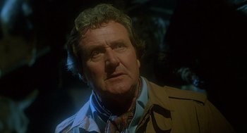 Movie still from “The Howling” (1981), directed by Joe Dante – An older man wearing a jacket and a tie; Close Up shot, Low angle
