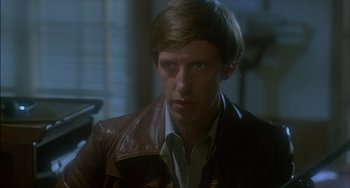 Movie still from “The Howling” (1981), directed by Joe Dante – A man wearing a brown leather jacket looking at the camera; Close Up shot, Over the shoulder angle