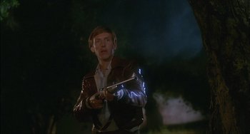Movie still from “The Howling” (1981), directed by Joe Dante – A man in a brown jacket holding a white stick; Medium shot, Low angle