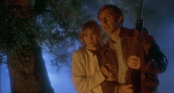 Movie still from “The Howling” (1981), directed by Joe Dante – A man and a woman standing next to each other in front of a tree; Close Up shot, Low angle