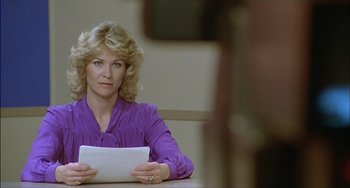 Movie still from “The Howling” (1981), directed by Joe Dante – A woman sitting at a table holding a tablet; Close Up shot, Over the shoulder angle