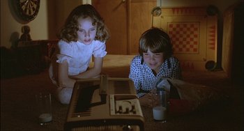 Movie still from “The Howling” (1981), directed by Joe Dante – Two young children sitting on the floor next to an old fashioned radio; Medium shot, High angle