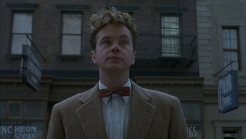 Movie still from “The Hudsucker Proxy” (1994), directed by Ethan Coen – A man in a suit and bow tie looking upward; Close Up shot, Low angle