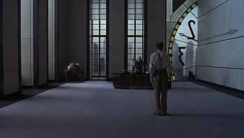 Movie still from “The Hudsucker Proxy” (1994), directed by Ethan Coen – A man standing in front of a large window; Extreme Wide shot, High angle