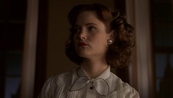 Movie still from “The Hudsucker Proxy” (1994), directed by Ethan Coen – A woman with a white shirt and a white bow tie; Close Up shot, Low angle