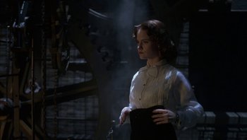 Movie still from “The Hudsucker Proxy” (1994), directed by Ethan Coen – A woman in a white shirt and black skirt; Medium shot, Low angle