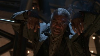 Movie still from “The Hudsucker Proxy” (1994), directed by Ethan Coen – An older man is holding his hands up in the air; Medium shot, Low angle