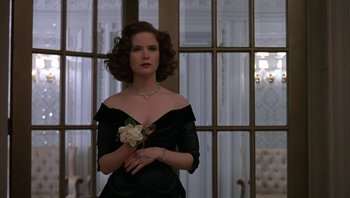 Movie still from “The Hudsucker Proxy” (1994), directed by Ethan Coen – A woman in a black dress holding a white rose; Medium shot, Low angle