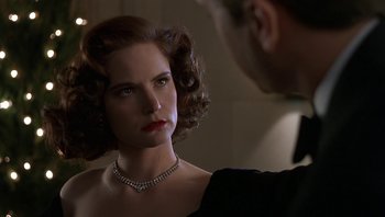 Movie still from “The Hudsucker Proxy” (1994), directed by Ethan Coen – A woman wearing a diamond necklace looking at a man in a suit; Close Up shot, Over the shoulder angle