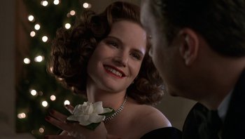 Movie still from “The Hudsucker Proxy” (1994), directed by Ethan Coen – A woman holding a white flower in her hand; Close Up shot, Low angle