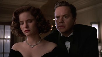 Movie still from “The Hudsucker Proxy” (1994), directed by Ethan Coen – A man and a woman in formal wear looking at the camera; Close Up shot, Low angle