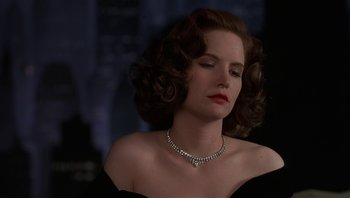 Movie still from “The Hudsucker Proxy” (1994), directed by Ethan Coen – A woman wearing a diamond necklace and a black dress; Close Up shot, Low angle