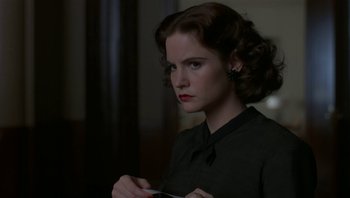 Movie still from “The Hudsucker Proxy” (1994), directed by Ethan Coen – A young woman holding a knife in her hands; Close Up shot, Over the shoulder angle