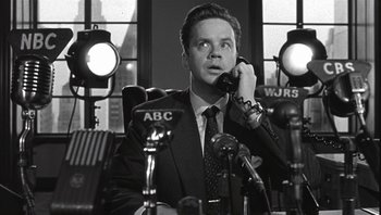 Movie still from “The Hudsucker Proxy” (1994), directed by Ethan Coen – A black and white photo of a man talking on a phone; Close Up shot, Low angle