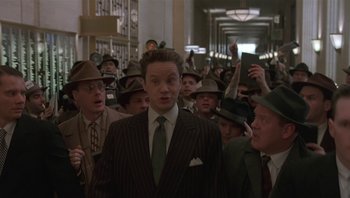 Movie still from “The Hudsucker Proxy” (1994), directed by Ethan Coen – A group of men in suits and hats in a hallway; Medium shot, Low angle