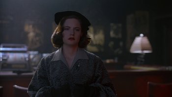 Movie still from “The Hudsucker Proxy” (1994), directed by Ethan Coen – A woman in a hat and a fur coat looking to her left; Close Up shot, Over the shoulder angle