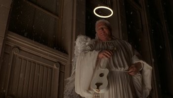 Movie still from “The Hudsucker Proxy” (1994), directed by Ethan Coen – An angel holding a ukulele in front of a halo; Medium shot, Low angle