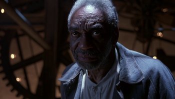 Movie still from “The Hudsucker Proxy” (1994), directed by Ethan Coen – An older man with a beard and a white shirt; Close Up shot, Low angle