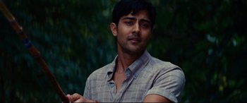 Movie still from “The Hundred-Foot Journey” (2014), directed by Lasse Hallström – A young man in a gray shirt is posing for a picture; Close Up shot, Over the shoulder angle