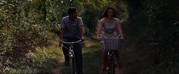 Movie still from “The Hundred-Foot Journey” (2014), directed by Lasse Hallström – A man and a woman riding bikes down a path; Wide shot, High angle