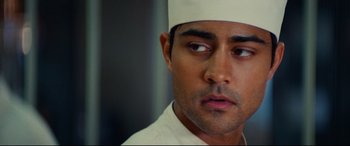 Movie still from “The Hundred-Foot Journey” (2014), directed by Lasse Hallström – A person wearing a hat; Close Up shot, Over the shoulder angle