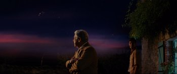Movie still from “The Hundred-Foot Journey” (2014), directed by Lasse Hallström – An older man standing in front of a night sky; Medium shot, Low angle