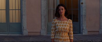 Movie still from “The Hundred-Foot Journey” (2014), directed by Lasse Hallström – A woman in a dress standing in front of a building; Medium shot, Over the shoulder angle