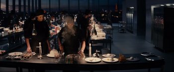 Movie still from “The Hundred-Foot Journey” (2014), directed by Lasse Hallström – A man standing in front of a table with plates on top of it; Wide shot, Low angle