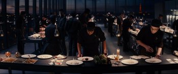 Movie still from “The Hundred-Foot Journey” (2014), directed by Lasse Hallström – A man standing at a table with plates of food; Wide shot, High angle