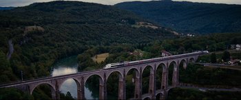 Movie still from “The Hundred-Foot Journey” (2014), directed by Lasse Hallström – A train is on a bridge over a river; Extreme Wide shot, High angle
