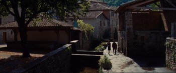Movie still from “The Hundred-Foot Journey” (2014), directed by Lasse Hallström – Two people walking down a stone path in a village; Extreme Wide shot, High angle