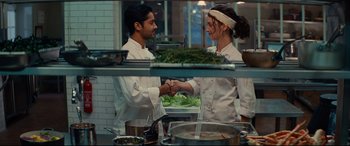 Movie still from “The Hundred-Foot Journey” (2014), directed by Lasse Hallström – Two chefs shaking hands in a kitchen; Medium shot, Over the shoulder angle