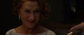 Movie still from “The Hundred-Foot Journey” (2014), directed by Lasse Hallström – A person smiling for the camera; Close Up shot, Over the shoulder angle