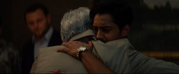 Movie still from “The Hundred-Foot Journey” (2014), directed by Lasse Hallström – A man hugging another man in a room; Close Up shot, Over the shoulder angle