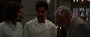Movie still from “The Hundred-Foot Journey” (2014), directed by Lasse Hallström – A man in a chef's outfit standing next to a woman; Close Up shot, Over the shoulder angle