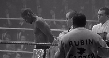 Movie still from “The Hurricane” (1999), directed by Norman Jewison – A man standing in a boxing ring next to a referee; Medium shot, Low angle