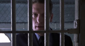 Movie still from “The Hurricane” (1999), directed by Norman Jewison – A man in a suit behind a metal fence; Close Up shot, Low angle