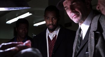 Movie still from “The Hurricane” (1999), directed by Norman Jewison – A group of men standing next to each other in a room; Medium shot, Over the shoulder angle