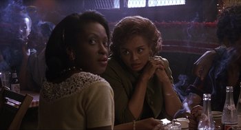 Movie still from “The Hurricane” (1999), directed by Norman Jewison – Two women sitting at a table in front of each other; Close Up shot, Over the shoulder angle