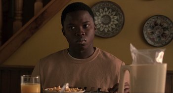 Movie still from “The Hurricane” (1999), directed by Norman Jewison – A young man holding a plate of food in front of him; Close Up shot, Over the shoulder angle