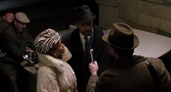Movie still from “The Hurricane” (1999), directed by Norman Jewison – A man in a hat is talking to a woman in a fur coat; Close Up shot, Over the shoulder angle