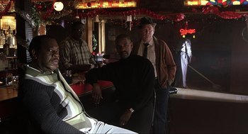 Movie still from “The Hurricane” (1999), directed by Norman Jewison – A group of men standing around a bar; Medium shot, Over the shoulder angle