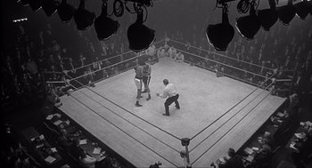 Movie still from “The Hurricane” (1999), directed by Norman Jewison – Two men in a boxing ring in front of a crowd of people; Extreme Wide shot, High angle
